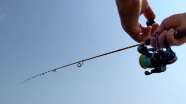 Elinde olta tutan bir adam.