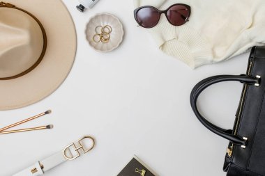 Beyaz arka planda şık kadın aksesuarları olan düz yatıyordu. Mücevher, şapka, çanta ve diğer eşyalar, üst görünüm