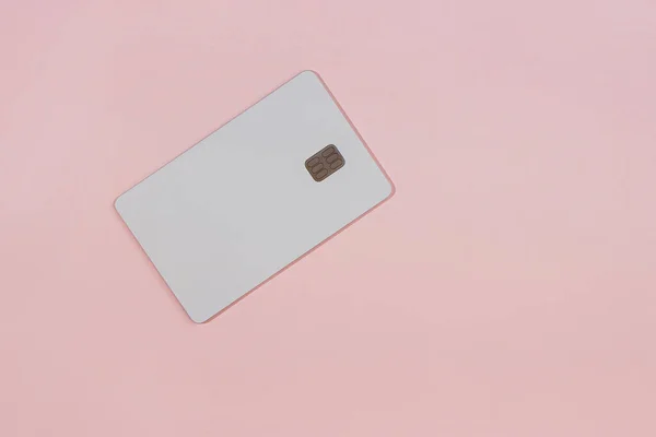 stock image White credit card with chip isolated on the pink background, real photo