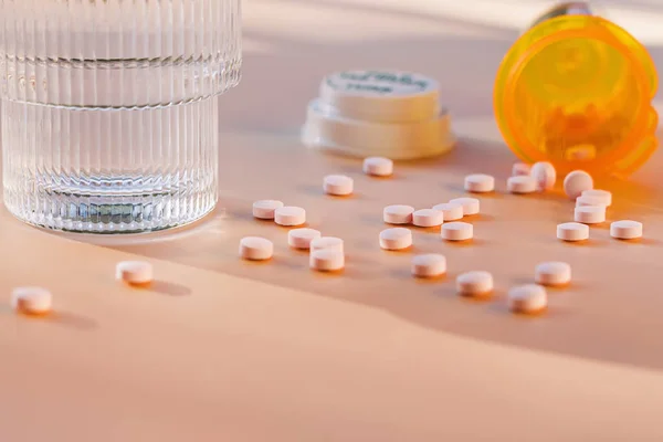 Крупный План Таблеток Разбросанных Столу Оранжевая Пластиковая Бутылка Лекарствами Стакан — стоковое фото