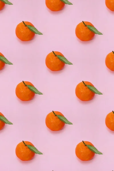 Mandarin oranges pattern on pink background. Creative pattern, fruit background.