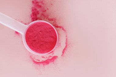 Pembe arka planda sublimleşmiş meyve tozu, yiyecek takviyesi üst görünümü.