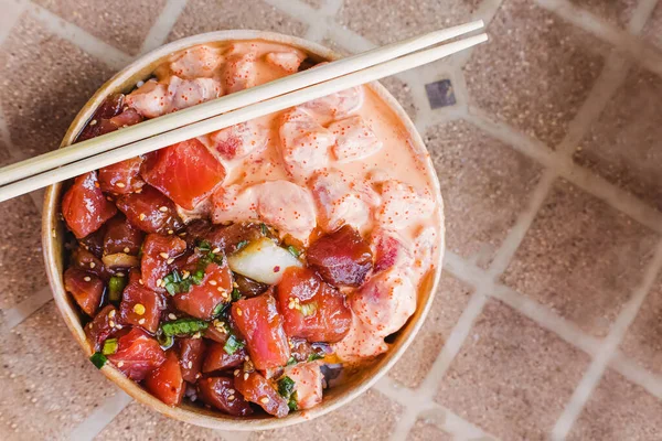 Two types of delicious traditional hawaiian poke in a paper bowl, top view
