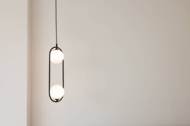Modern hanging lights over the white wall. Minimalist interior design