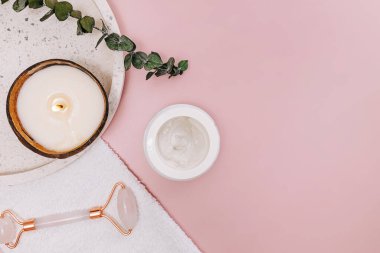 Still life with body and face care items on pink background, top view