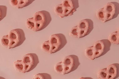 Strawberry Sweet Mini pretzels covered with pink glaze, treats background