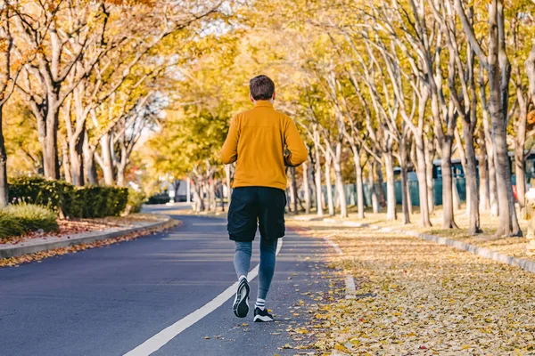 Muž Běží Běhá Venku Ulici Podzimními Stromy Žlutými Listy Obou — Stock fotografie
