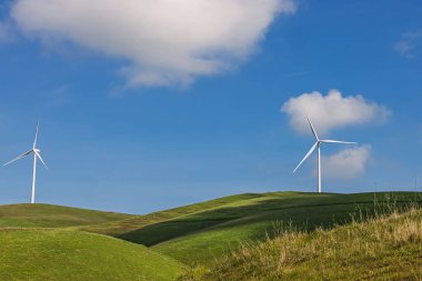 Yeşil tepelerdeki rüzgar santrali, temiz enerji.