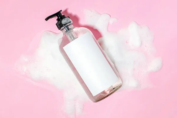ブランクラベルのシャンプーや液体石鹸 ピンクの背景に化粧品モックアップのボトル — ストック写真