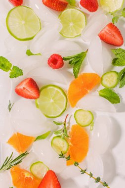 Turunçgil dilimleri, otlar ve böğürtlenlerle ferahlatıcı yaz kompozisyonu.