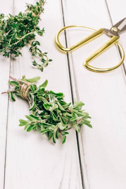 Bir sürü taze keklik otu yakın plan. Beyaz ahşap masada otlar