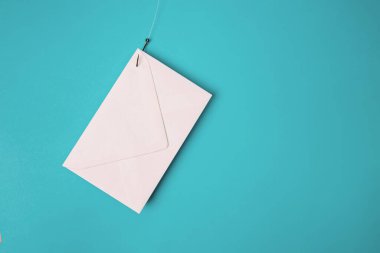 Balık oltasında beyaz bir zarf var. Sahte e-posta konsepti, siber güvenlik, veri sızıntısı