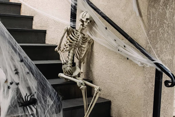 Scary Halloween decor outside the house, Skeleton sitting on the stairs
