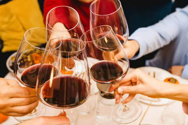 感恩节餐桌前 两只手握着满满一杯酒的红葡萄酒 — 图库照片