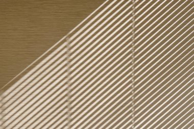 Güneş ışığı, duvarda çizgili gölgeler oluşturan, soyut arkaplan panjurlarına girdi.