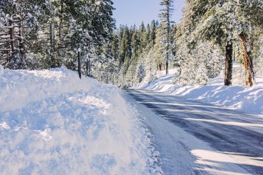 Yol kenarlarında çok kar olan kış yolu, karlı yollarda sürüş.