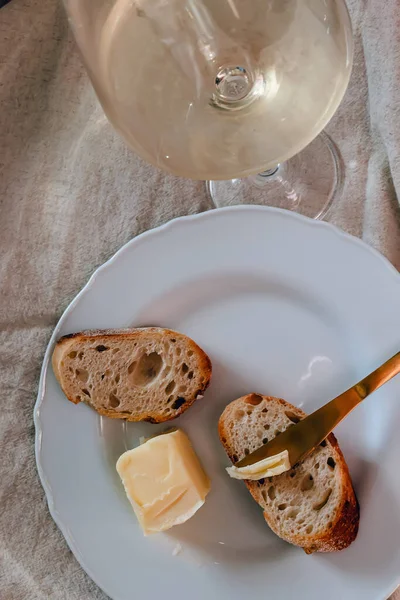 两片新鲜的面包加黄油和一杯白葡萄酒的特写 优雅的生活方式 — 图库照片