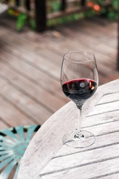 红葡萄酒倒立在院子里的木制桌子上 — 图库照片