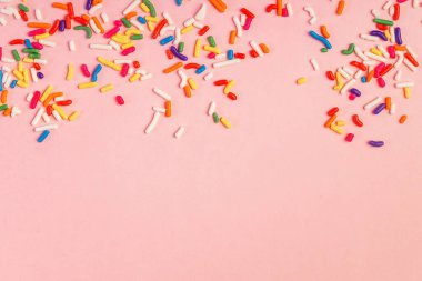 Fotokopi alanı ve parti arkaplanı olan pembe arkaplana renkli şeker serpintileri