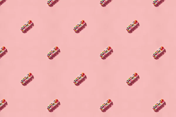 カラフルな砂糖で満たされた医療用錠剤カプセルで作られたパターンは ピンクの背景で単離します 健康コンセプト — ストック写真