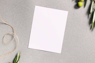 Kart ya da davetiye maketi, boş kağıt ve zeytin dalları, üst görünüm