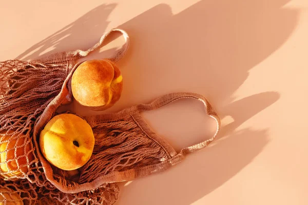 自然光下粉色背景的生态袋里的成熟桃子 顶视图 — 图库照片#