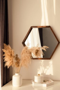 Günbatımında sıcak bir gün batımında vazoda dekoratif pampass otları olan modern bir iç mekan.