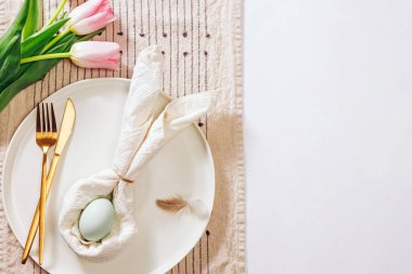 Paskalya için servis edilen masa, peçeteyle kaplanmış tavşan kulağı ve mavi yumurta şeklinde.