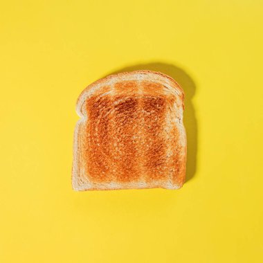 Kare ekmek dilimi, sarı arka planda izole edilmiş tost.