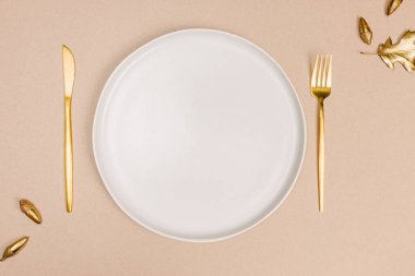 Boş tabak ve altın çatal bıçak seti, güz masası seti, üst manzara.