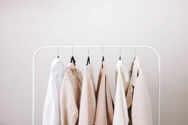 Beyaz ve bej renkli gardırop esasları, şık bir kadın rafta kapanıyor.