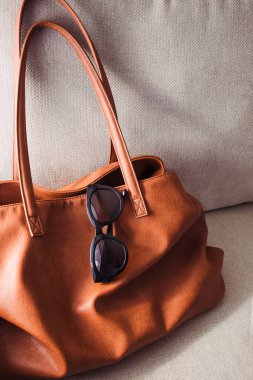 Kahverengi deri çanta ve şık güneş gözlükleri, modern moda.