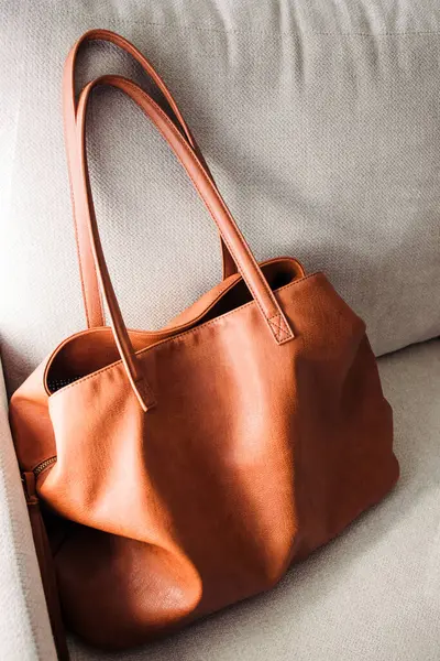 stock image Brown leather bag standing on the sofa