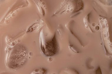 Creamy iced beverage or coffee with droplets and ice cubes in mocha mousse color 2025 clipart