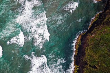 Güzel okyanus dalgaları kayalık kıyı şeridine çarpıyor.
