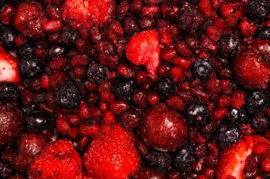 Çeşitli donmuş karışık meyveler. Canlı kırmızı ve koyu mavi renkler.