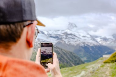 Yürüyüşçü, İsviçre Alplerinde yürüyüş yaparken Matterhorn 'un nefes kesici görüntülerini yaklaştı.
