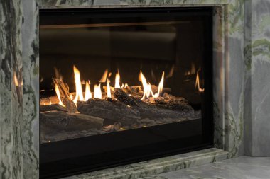 Burning gas fireplace built into marble clipart