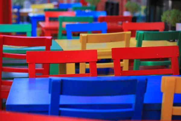 Colorful chairs and tables at outdoor area of cafe close-up