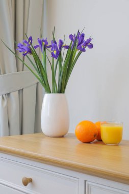 Vazoda Hollanda zambağı ve bardakta portakal suyu.