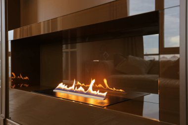 Mobilyaların içine inşa edilmiş modern çevresel etanol şöminesi yanıyor. 