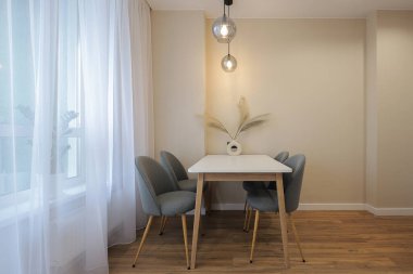 Modern mutfak içinde sandalyeli yemek masası.