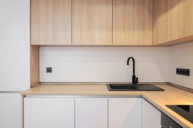 Modern mutfakta musluk ve granit lavabo var.