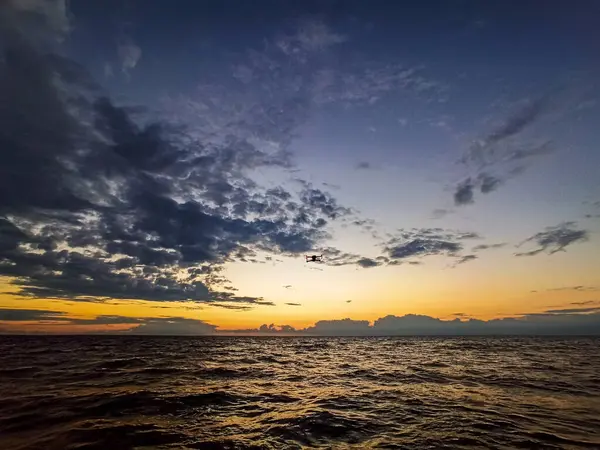 日没で海上を飛行するドローン — ストック写真