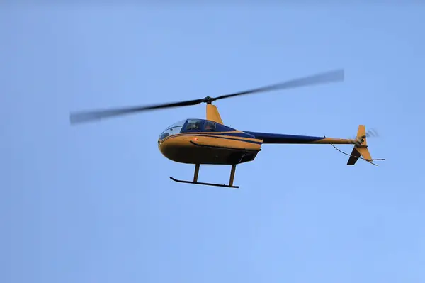 直升机鲁宾逊R44在蓝天飞行 图库图片