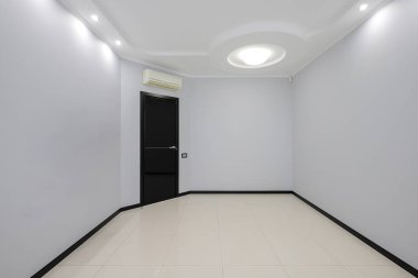 Dairenin içinde siyah kapısı olan boş gri bir oda.