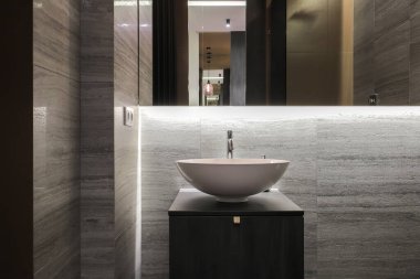 Banyoda seramik lavabo ve ayna olan musluk. 