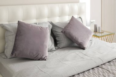 Yatak odasındaki çift kişilik yatakta yastıklar.