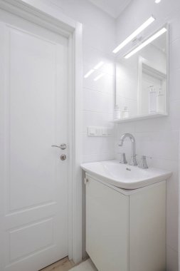 Banyoda seramik lavabo ve ayna olan musluk.