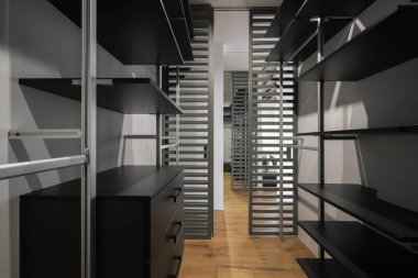 Soyunma odasında rafları olan gardırop.